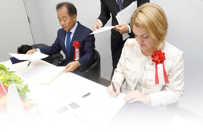 マケドニア語・日本語・英語、それぞれの言語での覚書にサインする様子
